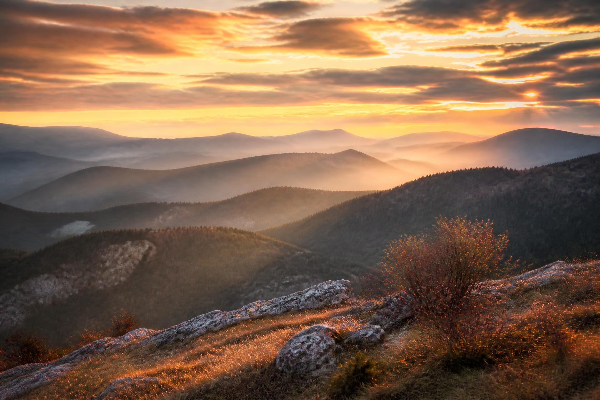 Misty mountain ridges in Bulgaria glowing at sunrise